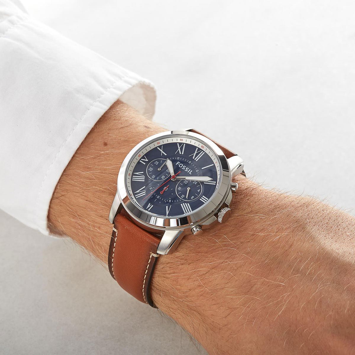 Fossil Grant FS5210 chronograph watch worn on wrist with navy dial and brown leather strap
