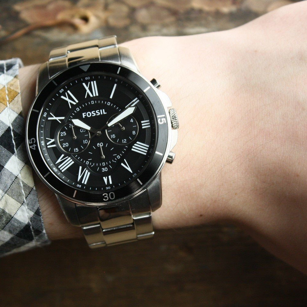 Fossil Grant Sport chronograph watch worn on wrist with black dial and steel bracelet