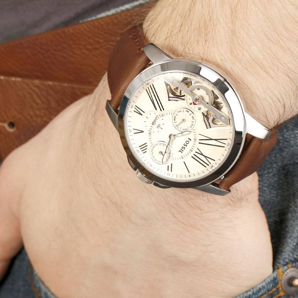 Fossil Grant Twist watch on wrist showing skeleton window detail and Roman numeral dial
