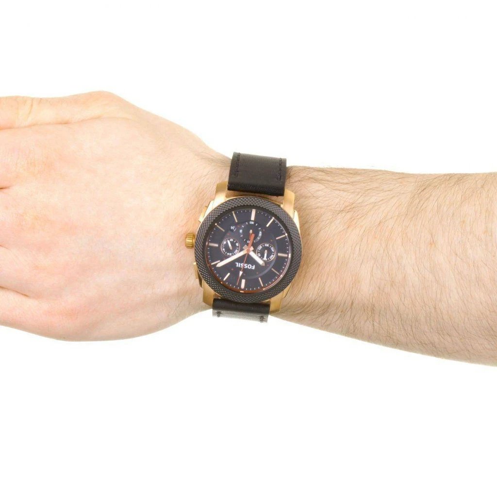 Fossil Machine chronograph watch worn on wrist with black strap and gold case