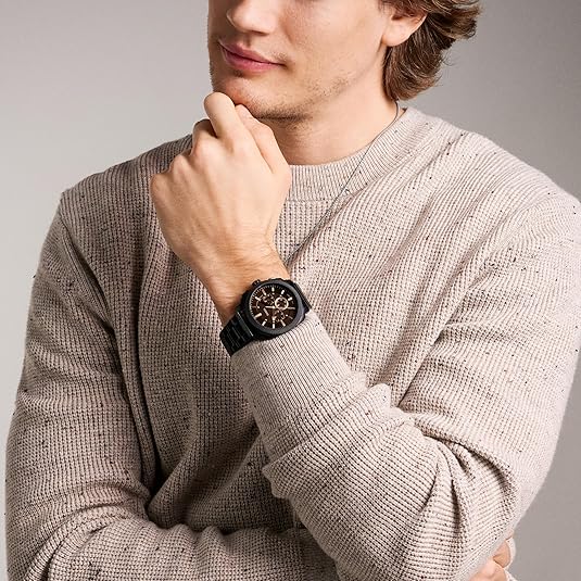 Model wearing Fossil Machine watch with brown dial on black bracelet, styled casual look