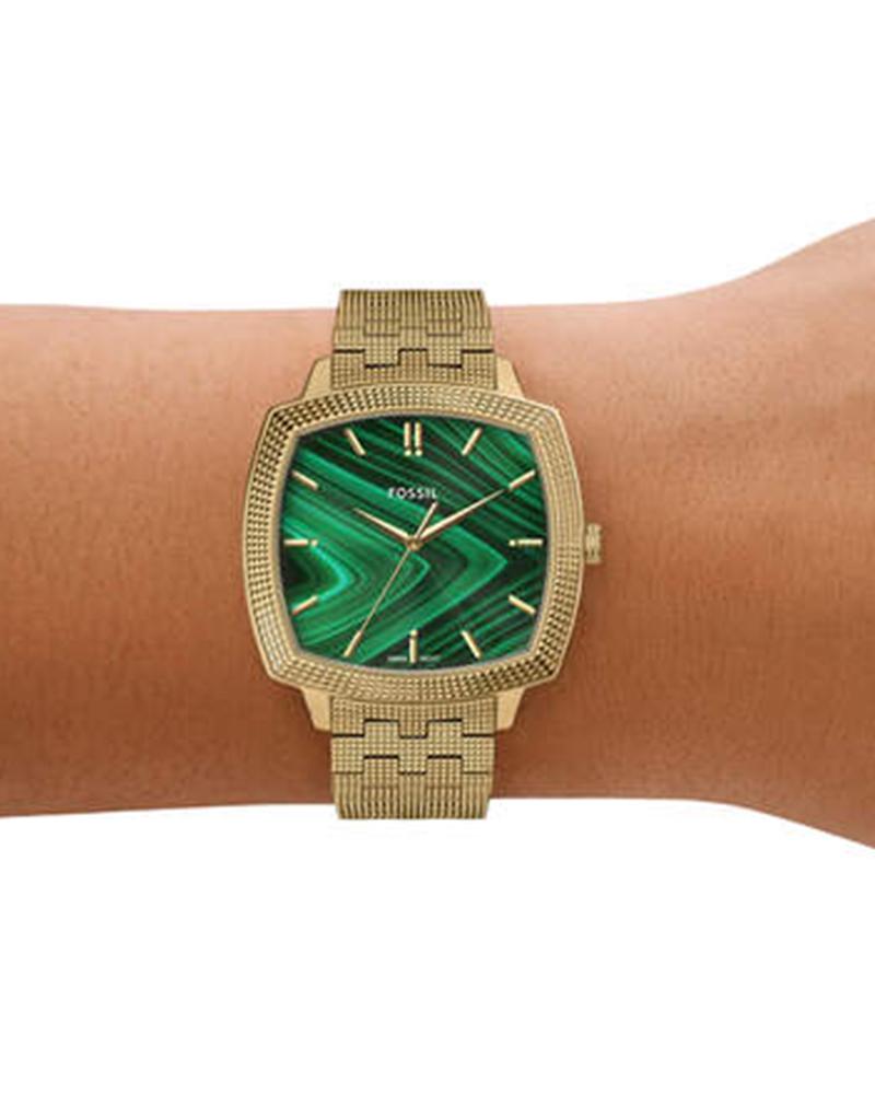 Watch worn on wrist showing green malachite dial and gold-tone mesh bracelet