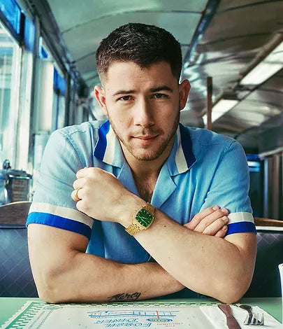Person wearing gold-tone watch with malachite dial on wrist