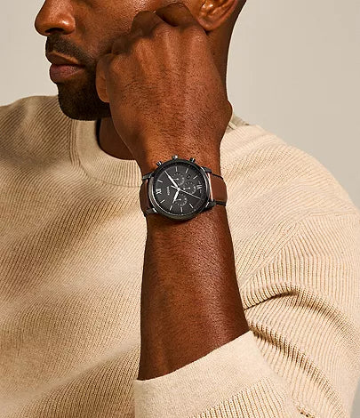 Fossil Neutra chronograph watch worn on wrist of man in beige sweater
