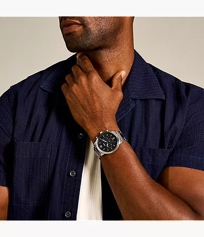 Fossil Neutra chronograph watch worn on man's wrist with navy shirt