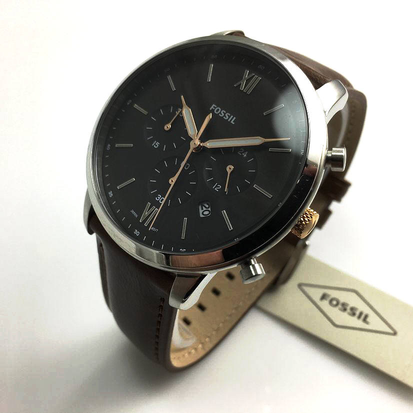 Angled view of Fossil Neutra chronograph with light brown leather band and Fossil tag packaging