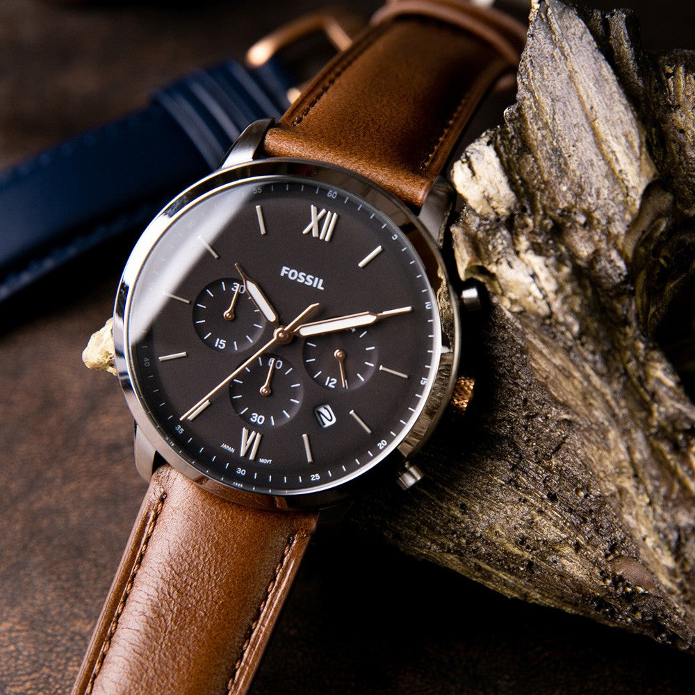 Fossil Neutra chronograph watch with light brown leather strap displayed outdoors on stone surface