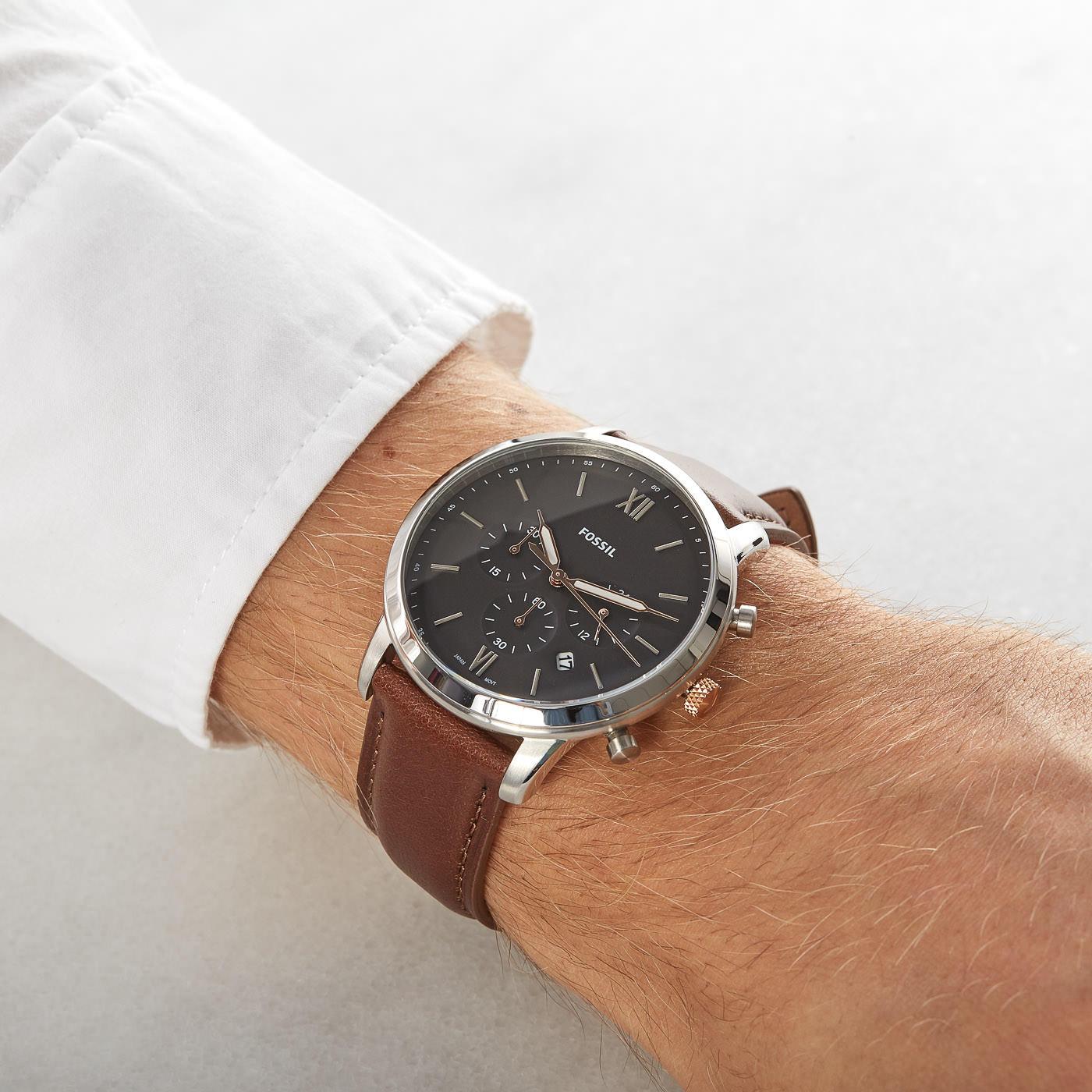 Fossil Neutra chronograph watch on wrist with light brown leather band and white shirt sleeve
