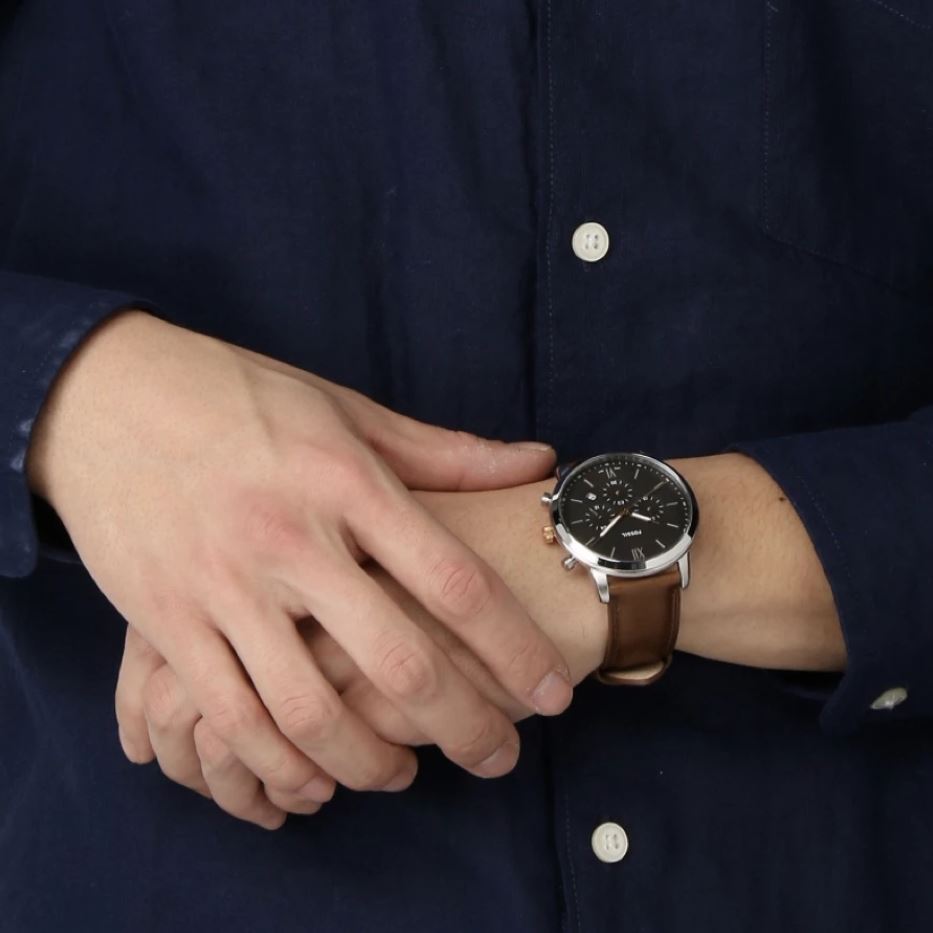 Fossil Neutra men's chronograph watch on wrist with dark blue shirt and light brown leather strap