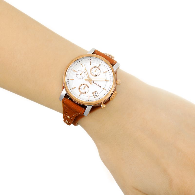 Women's chronograph watch on wrist showing silver dial and brown leather band