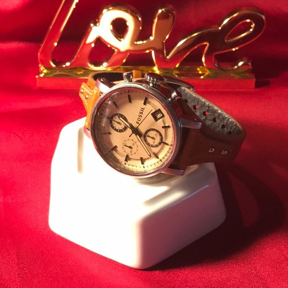 Fossil Original Boyfriend Sport watch on decorative stand with red background and gold accents