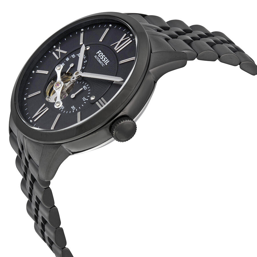Fossil Townsman automatic watch at side angle showing black dial, open heart window, and stainless steel bracelet
