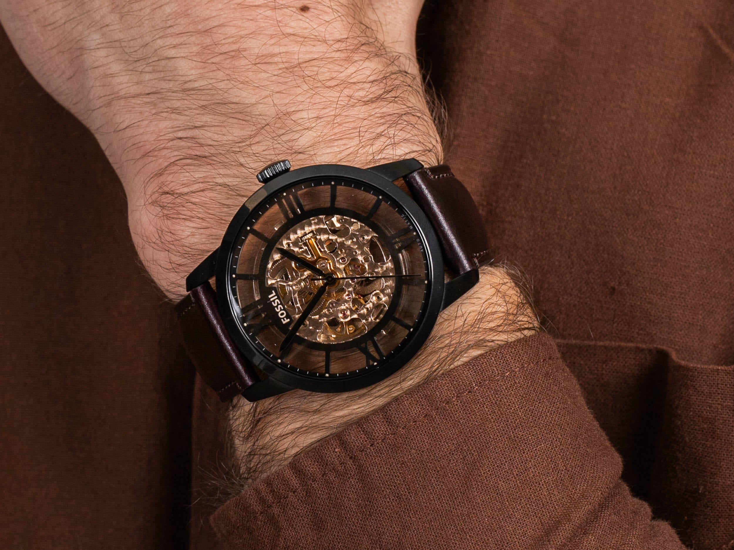Fossil Townsman automatic skeleton dial watch worn on wrist with brown leather strap