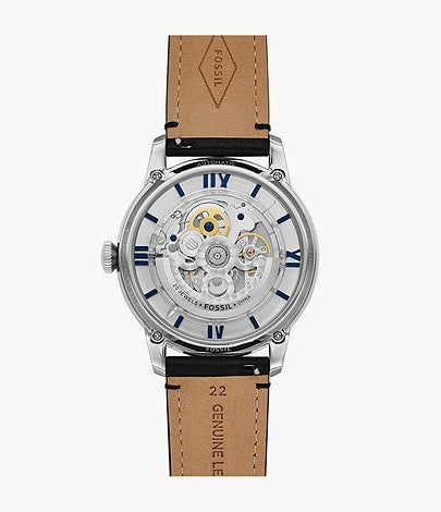 Fossil Townsman watch flat lay displaying skeleton dial with tan and black leather strap