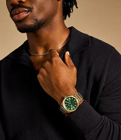 Fossil Everett gold-tone watch worn on wrist with green dial visible