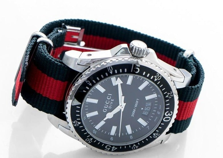 Gucci Dive YA136206 angled view showing black dial and striped green-red nylon strap