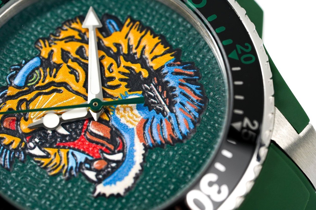 Gucci Dive YA136316 dial close-up showing yellow and orange tiger embroidery on green textured background