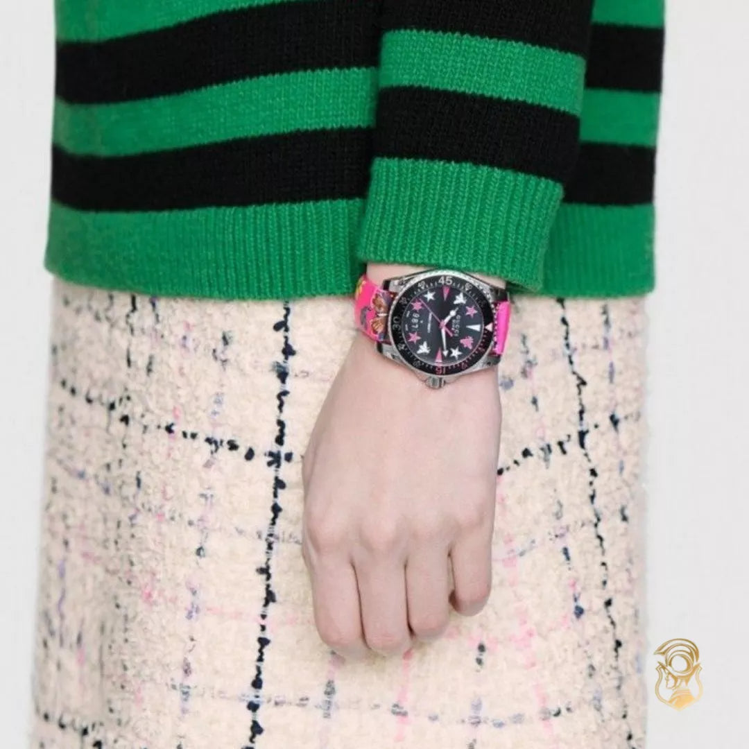 Gucci Dive Watch YA136326 on wrist with pink floral strap against green and black striped sleeve