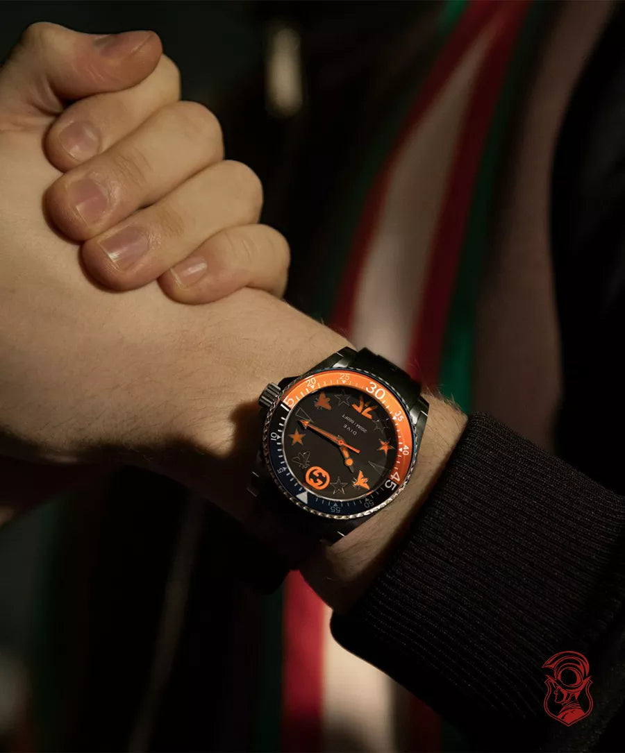 Gucci Dive 40mm watch worn on wrist with black dial and orange bezel visible