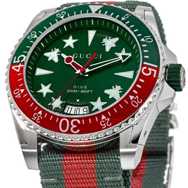 Close-up of green dial with white stars, GUCCI text, red rotating bezel with 15-minute markers