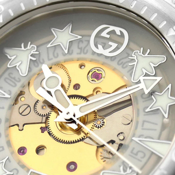 Gucci Dive YA136343 dial detail with skeletonized movement, gold rotor, and GG logo