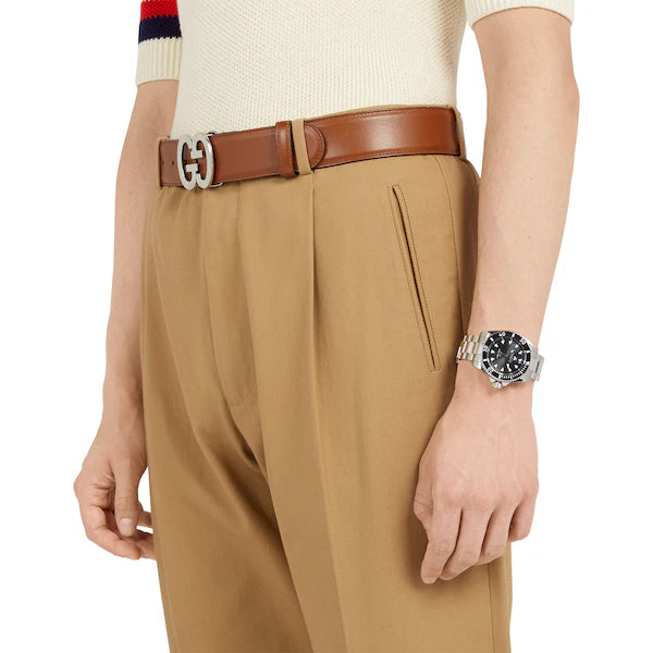 Gucci Dive watch on wrist with black dial and stainless steel bracelet worn on arm