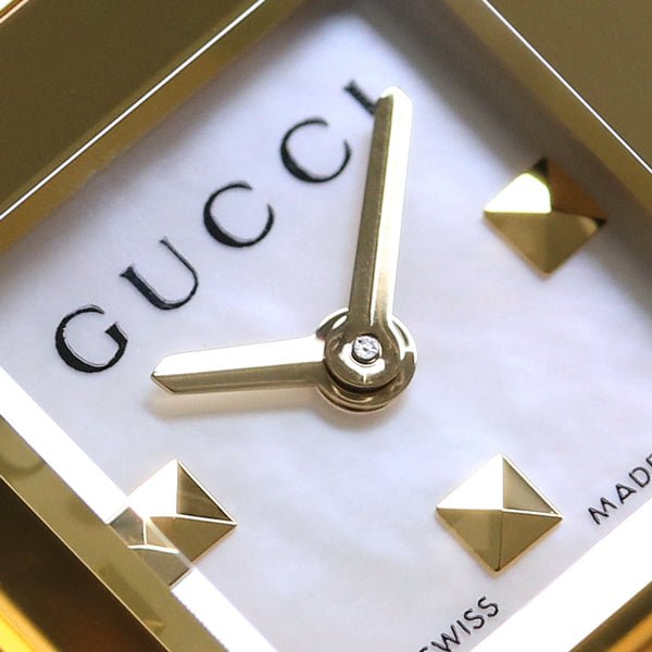 Gucci G-Frame dial detail showing white face with gold hour markers and hands
