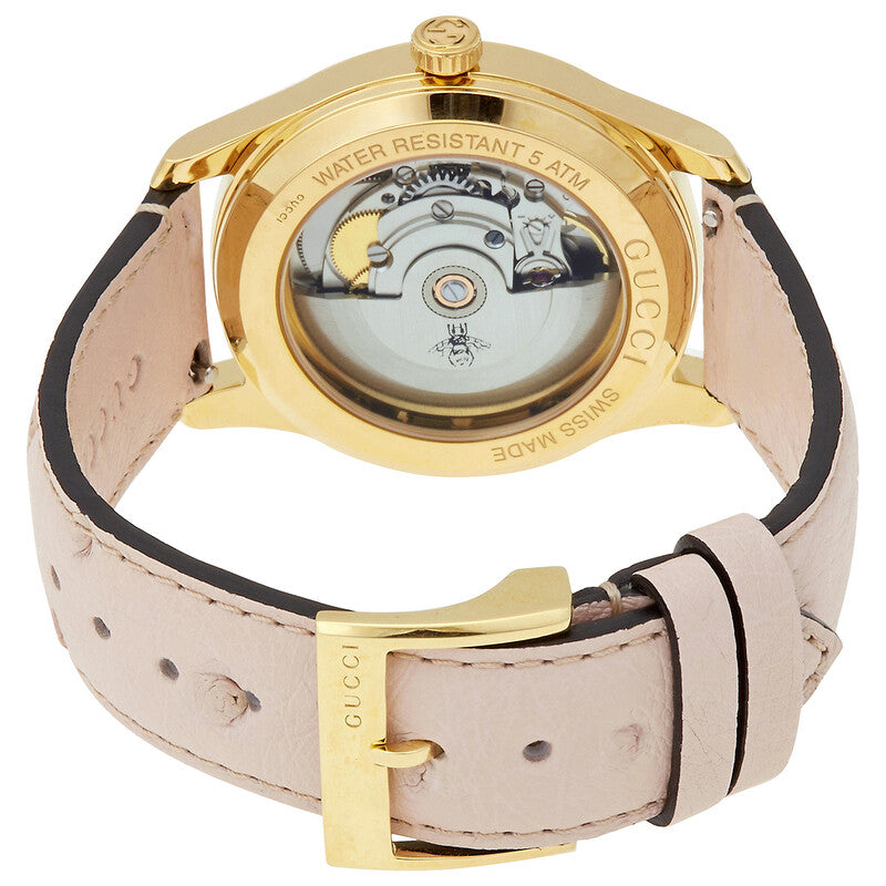Caseback of Gucci G Timeless watch showing automatic movement and glass exhibition window with pink and black leather strap