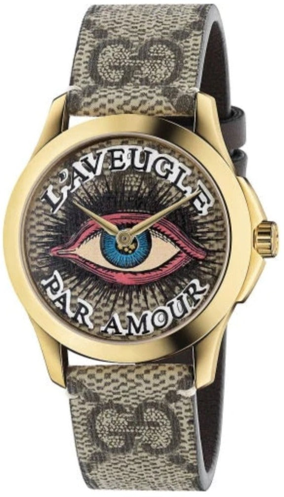 Gucci G-Timeless watch with eye motif dial, gold case, and GG canvas strap