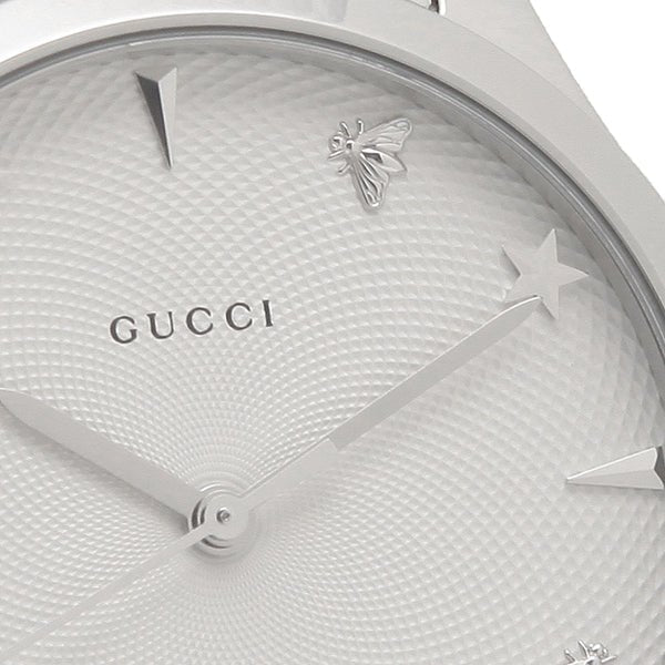 Close-up of Gucci G-Timeless dial showing guilloché pattern, star markers, and bee motif