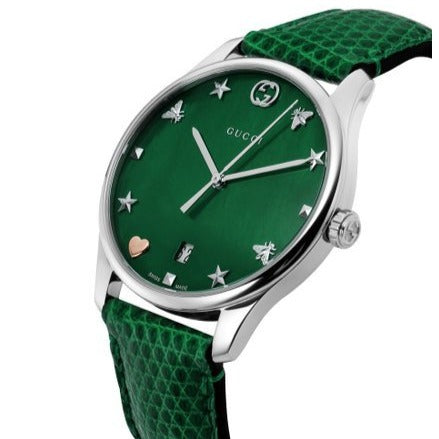 Gucci G-Timeless watch angled view showing green dial with star and charm hour markers and green leather strap