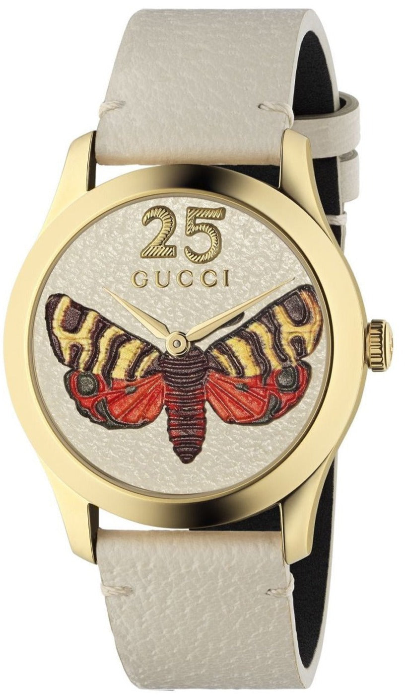 Gucci G-Timeless watch with gold case, butterfly dial, cream leather strap, and date window