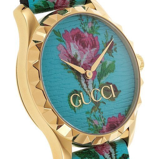 Close-up of aqua floral print dial with pink roses, Gucci branding, and gold-tone hands