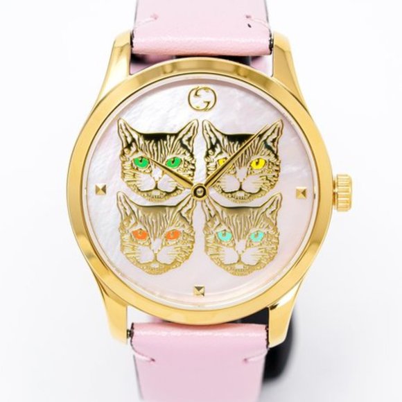 Close-up of Gucci G-Timeless dial featuring four cat heads with colored gemstone eyes on mother-of-pearl