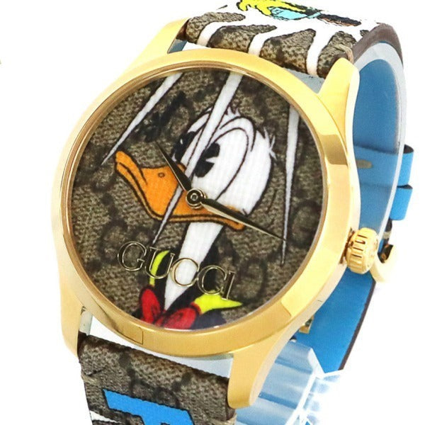 Angled view of Gucci G Timeless YA1264167 watch showing gold case, Donald Duck dial, and strap