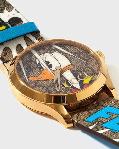 Gucci G Timeless YA1264167 watch worn on wrist showing Donald Duck dial and patterned strap