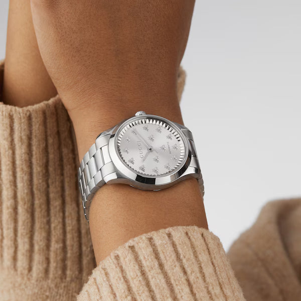 Gucci G-Timeless 38MM automatic watch on wrist with silver dial and stainless steel bracelet