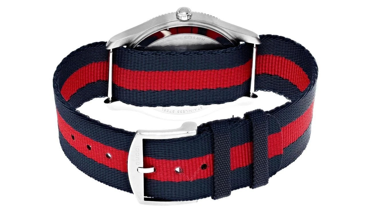 Navy and red striped nylon strap of Gucci G-Timeless watch with buckle closure