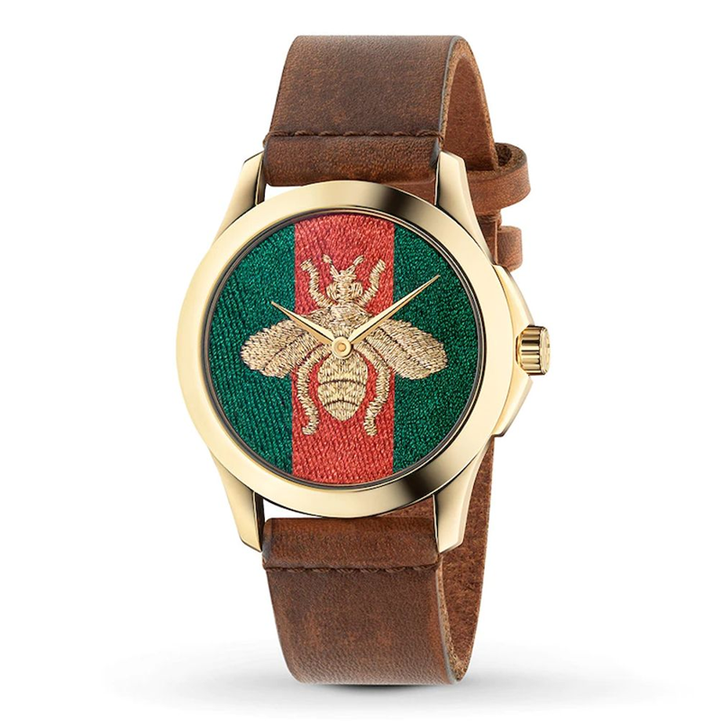 Gucci G Timeless watch with gold case, embroidered bee dial, and brown leather strap angled view