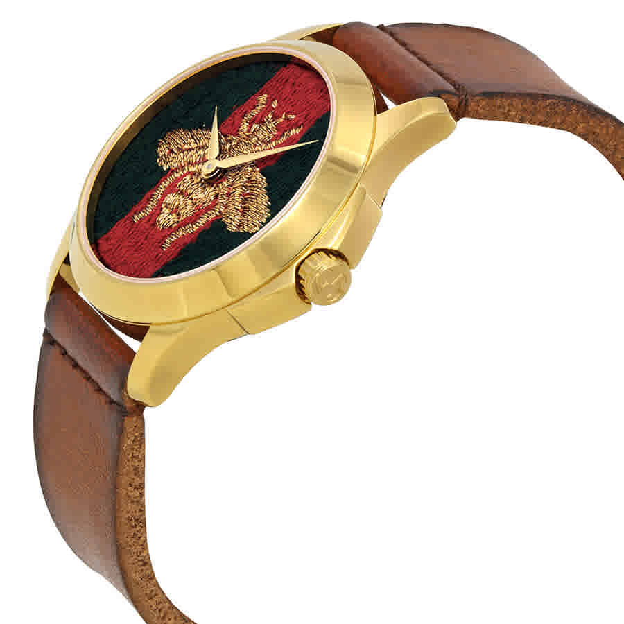 Gucci G Timeless watch worn on wrist displaying bee dial and brown leather band