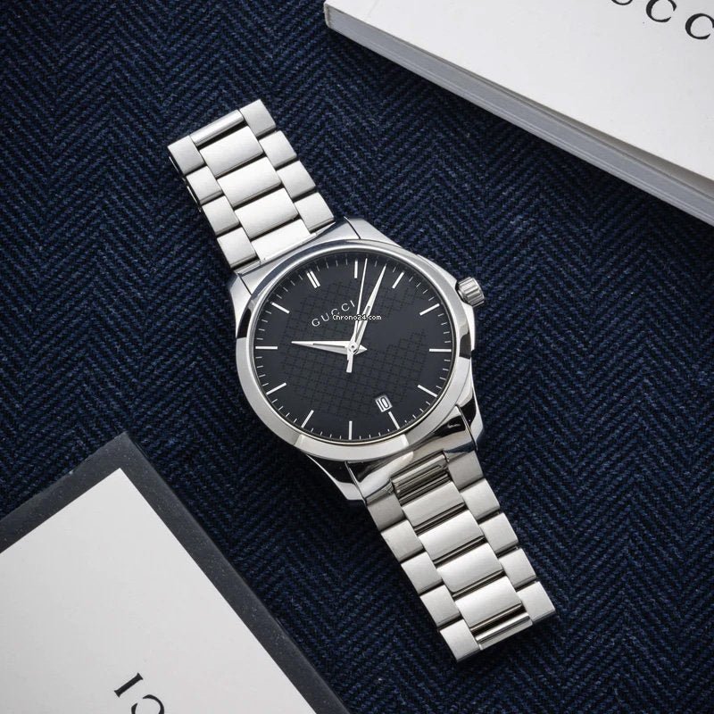 Gucci G-Timeless watch displayed flat with black dial detail