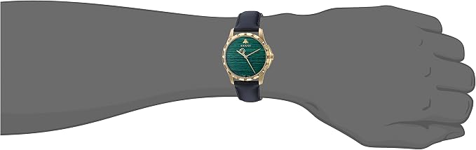 GUCCI G-Timeless watch worn on wrist with navy leather strap