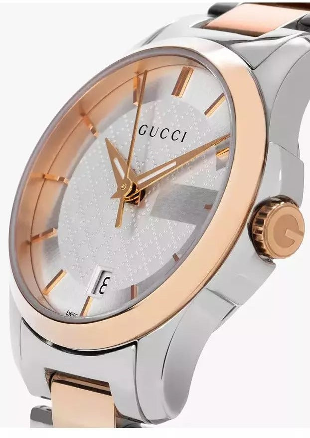 Gucci G-Timeless watch dial detail showing rose gold hour markers and hands with date window