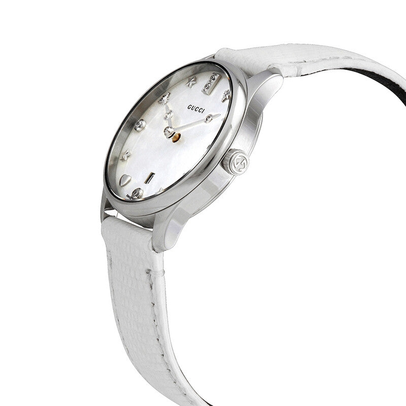 Gucci G-Timeless watch angled view showing white leather strap and mother-of-pearl dial with stainless steel bezel