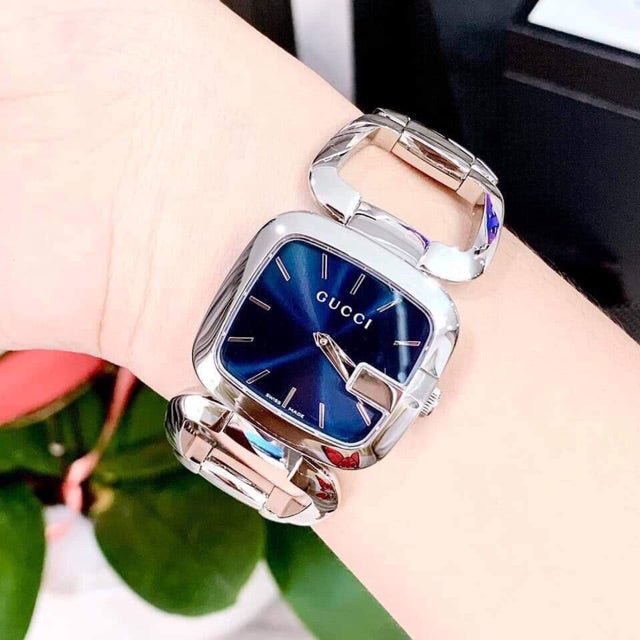 Gucci G Blue YA125508 women's watch worn on wrist, displaying blue dial and stainless steel bracelet
