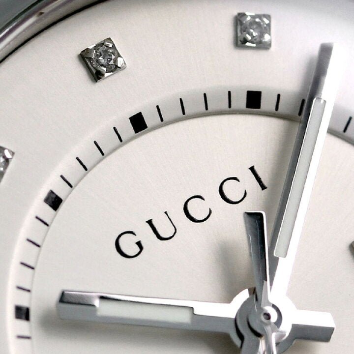 Close-up of Gucci GG2570 dial showing diamond hour markers and Gucci branding on white face