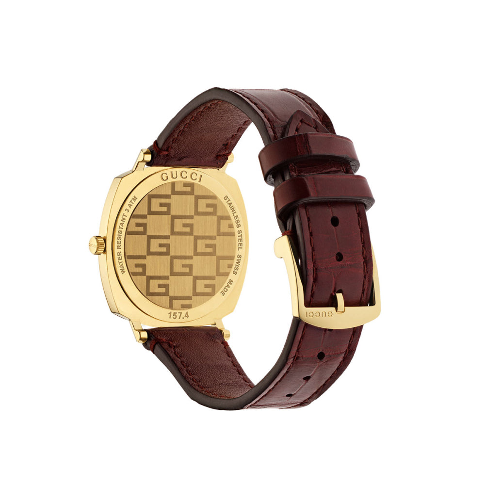 Side angle view of Gucci Grip watch showing gold case and burgundy leather strap