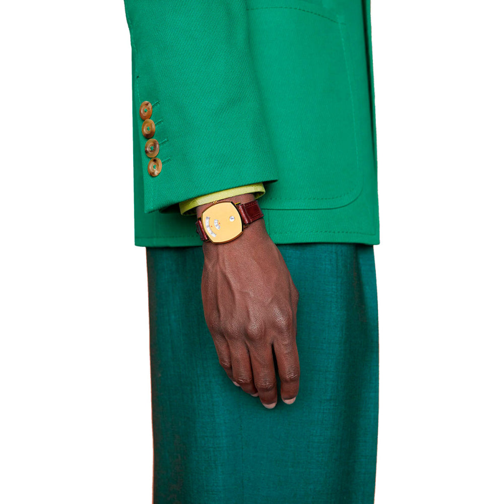 Gucci Grip women's watch worn on wrist with gold case and burgundy leather strap