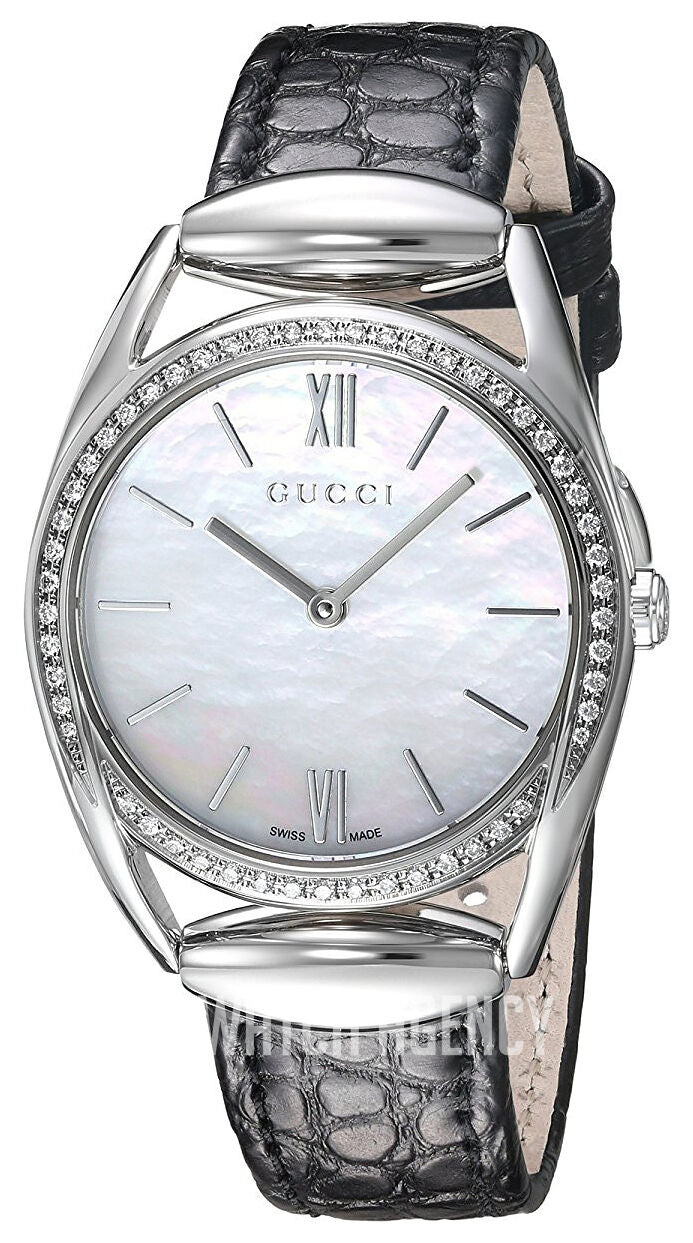 Gucci Horsebit watch with diamond bezel on wrist, showing white mother-of-pearl dial and black crocodile-pattern leather strap