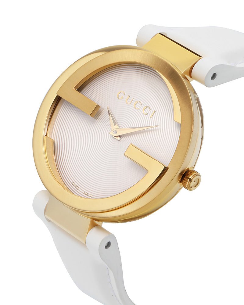 Angled view of Gucci Interlocking watch showing gold case and white leather strap